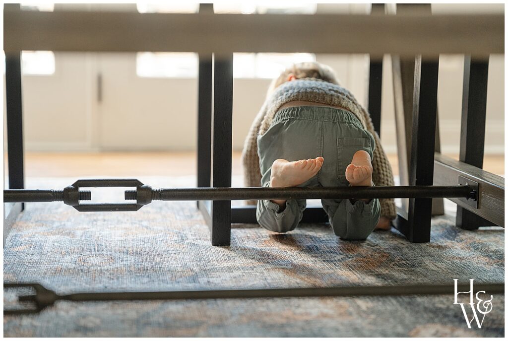 boy crawling under the table