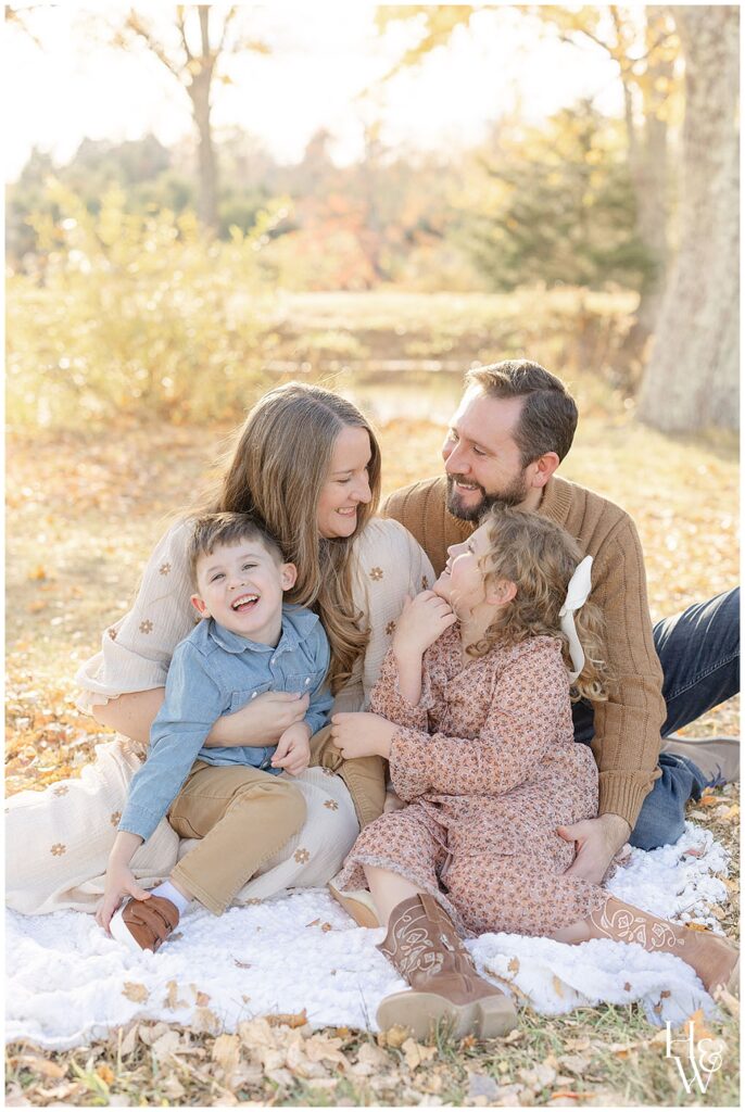 Family cuddling together on a blanket during a fall portrait session