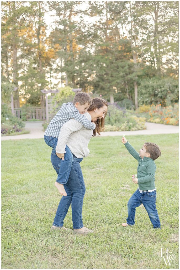 Mom giving her son a piggyback ride while playing outdoors