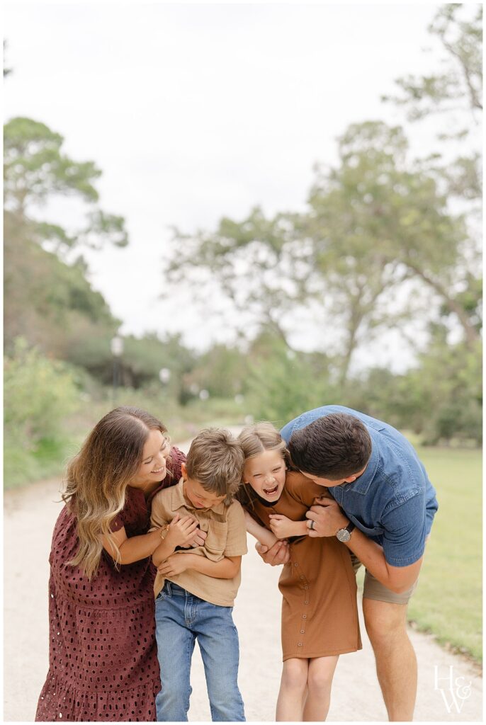 Parents laughing with their children during a playful family photography session